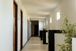 A hallway with wooden doors, a black and white counter, and a plant.