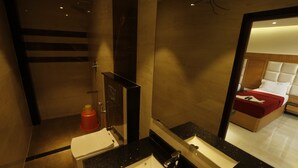 A modern bathroom with a large mirror, a sink, and a shower. - New Cape Hotel (Nagercoil)