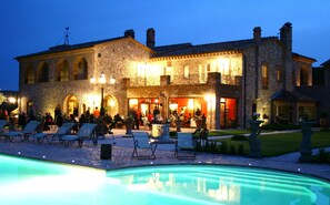 A stone building with outdoor seating and a swimming pool. - Relais Tenuta del Gallo (Amelia)