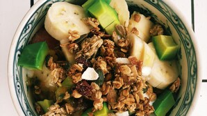 A bowl of food with bananas, avocado, and granola. - Le Printemps D' An Bang (Da Nang)