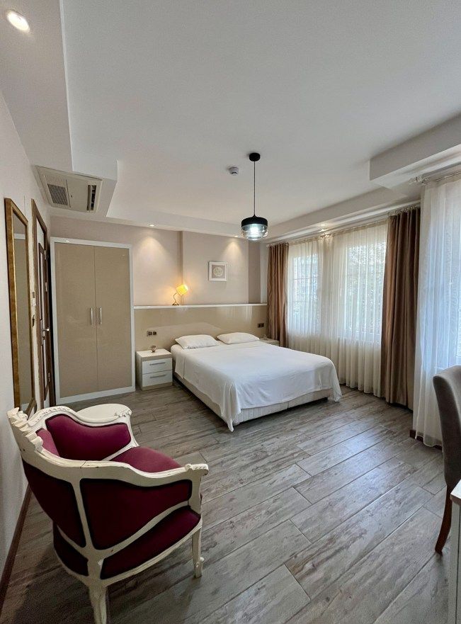 Una habitación de hotel con una cama, una mesita de noche, una silla y un armario.