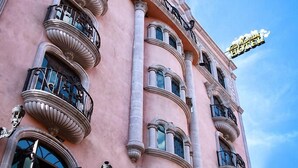 A pink building with multiple balconies and a sign that reads "Hotel". - Hotel Hacienda Los Narcisos (San Juan de los Lagos)