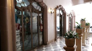 A lobby with checkered flooring, ornate columns, and a glass door entrance. - Hotel Hacienda Los Narcisos (San Juan de los Lagos)