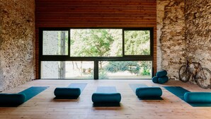 Ein Zimmer mit großem Fenster, Holzboden und blau gepolsterten Sitzgelegenheiten.