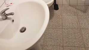 A bathroom with a sink, toilet, and shower. - Jaude Stay Aparthotel (Clermont-Ferrand)