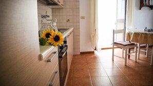 A kitchen with a sink, a chair, and a table. - Casa Giuliana (Lipari)