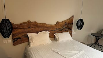A bedroom with a wooden headboard, two white pillows, and a neatly made bed.