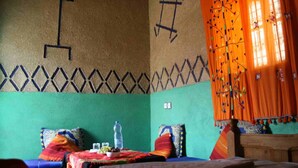 A room with a bed, a wooden headboard, a green wall, and a patterned ceiling. - Kasbah Casa Khamlia (Taouz)