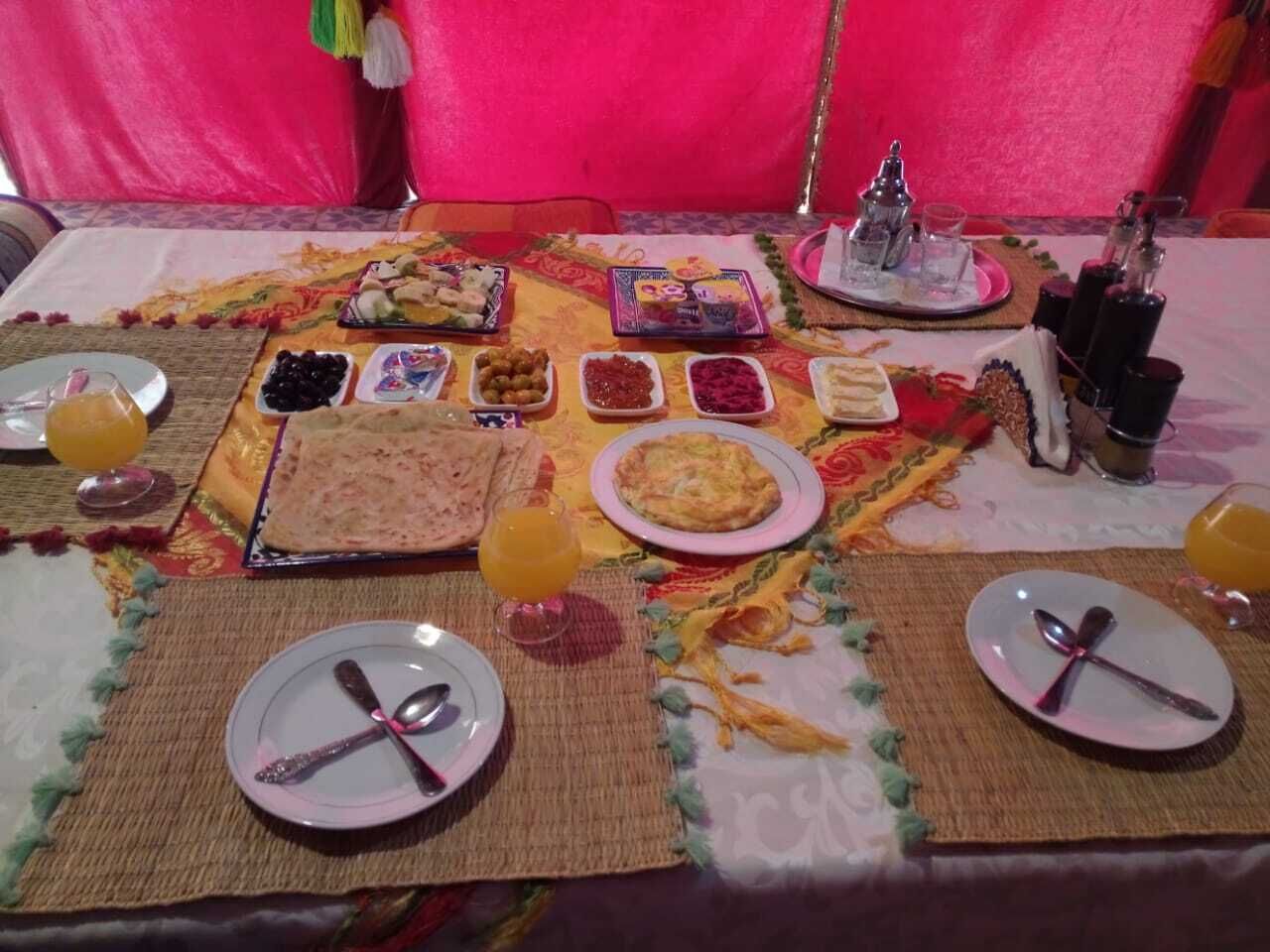A table set with various dishes, including bread, fruits, and a plate of eggs.