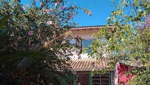 A house with a tiled roof, a front door, and a small porch area. - Inefável Hostel Floripa (Florianópolis)