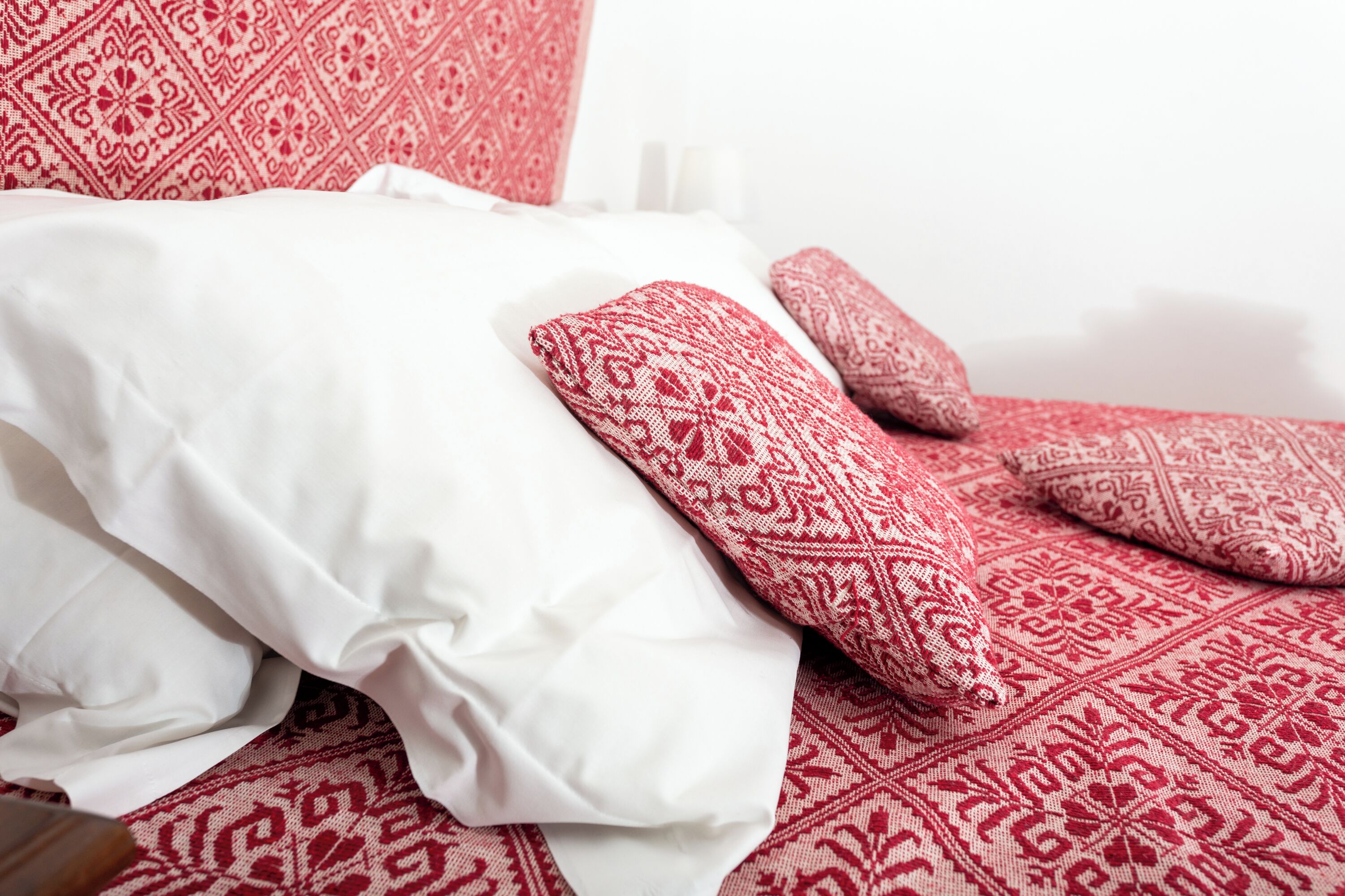 Een bed met beddengoed in een wit en rood patroon.
