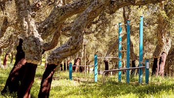 Uma árvore com uma estrutura metálica em uma área gramada.