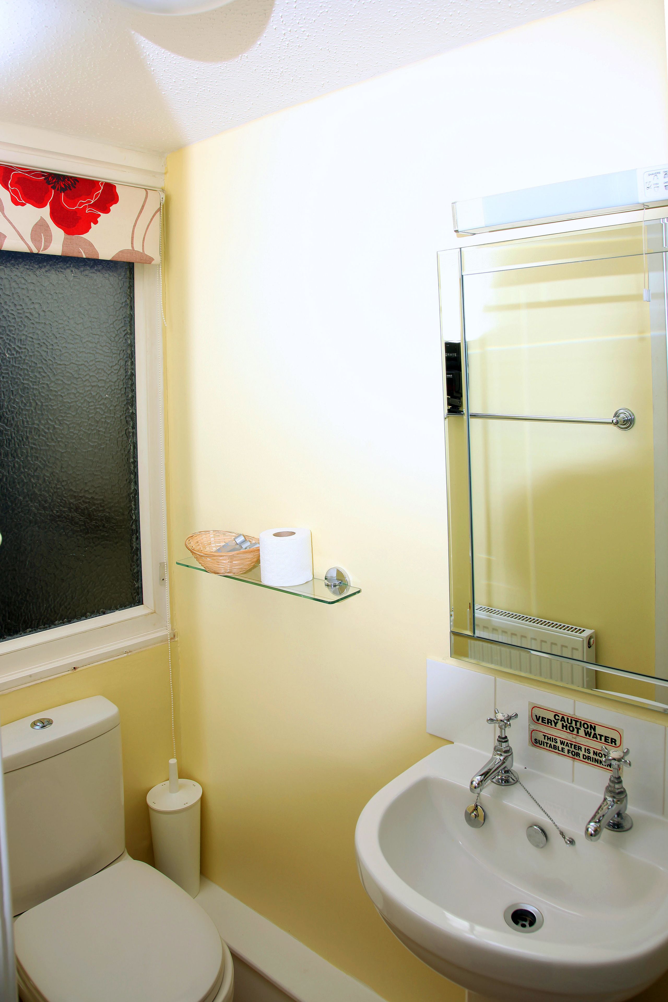 Un bagno piccolo con il water, un lavandino e uno specchio.