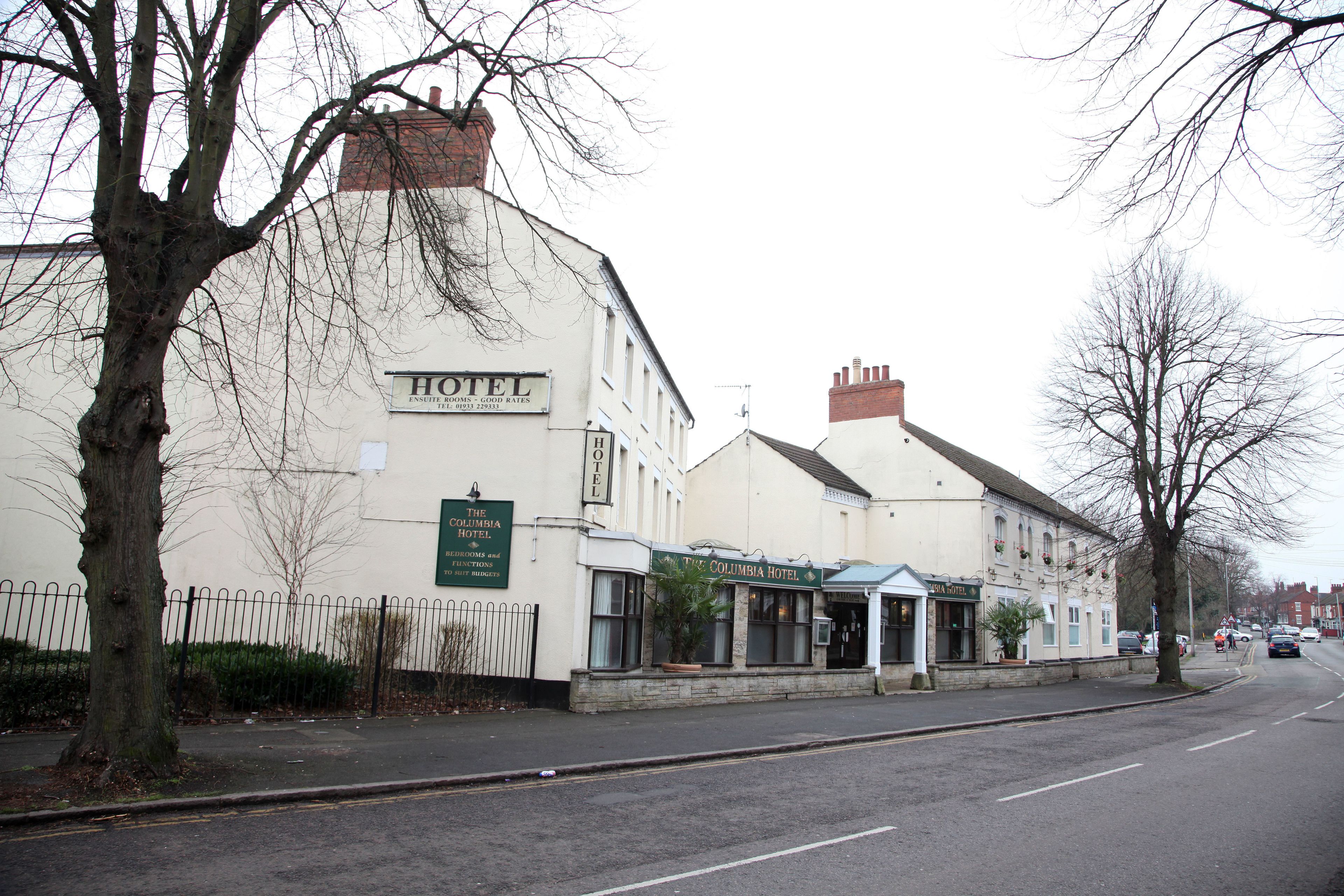A two-story hotel with a signboard indicating it is a hotel.