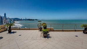 Una terraza en la azotea con vistas al océano y al horizonte de la ciudad.