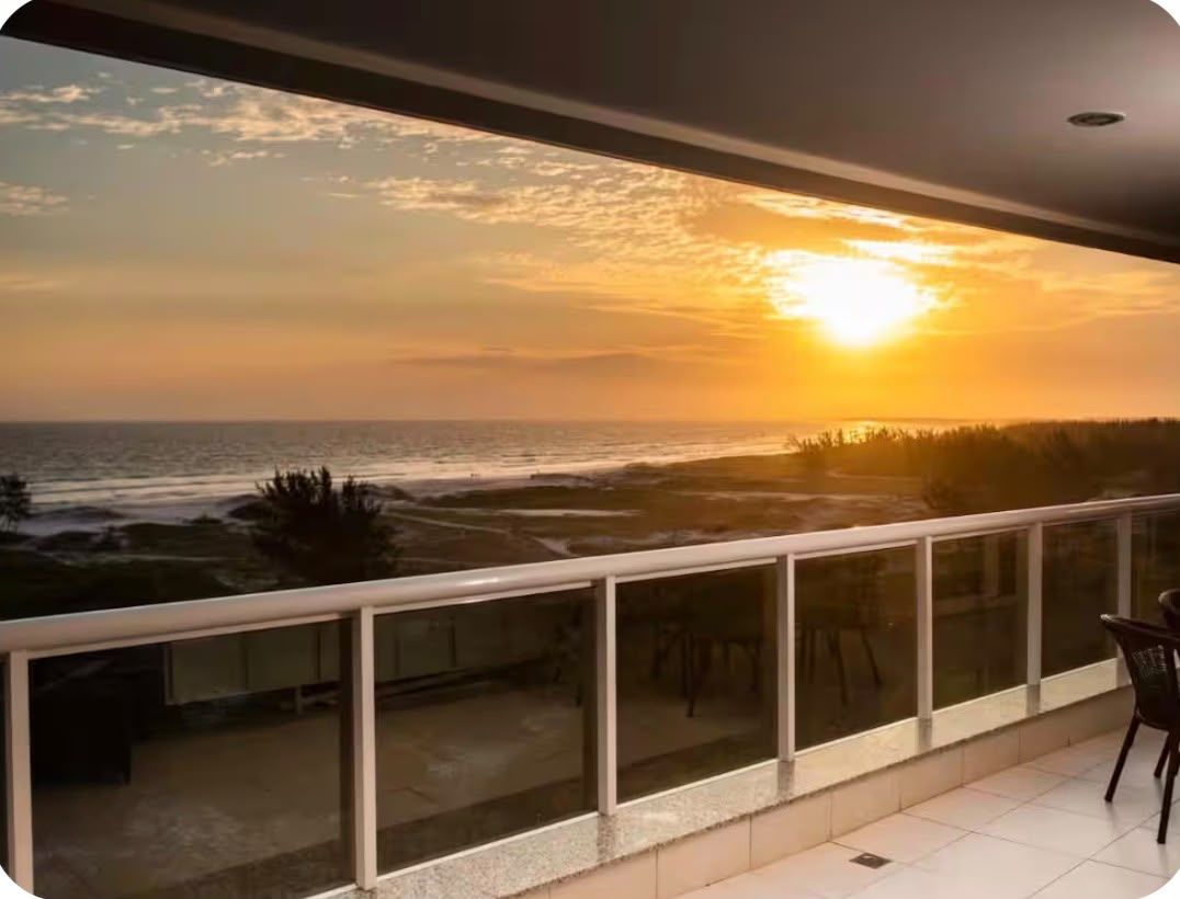 Ein Balkon mit Blick auf das Meer im Sonnenuntergang.