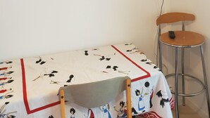 A room with a bed, a television mounted on the wall, two chairs, and a table with a tablecloth. - Residence Terminus housing  (Clermont-Ferrand)