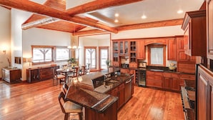 A spacious kitchen with wooden beams, granite countertops, and a large island.