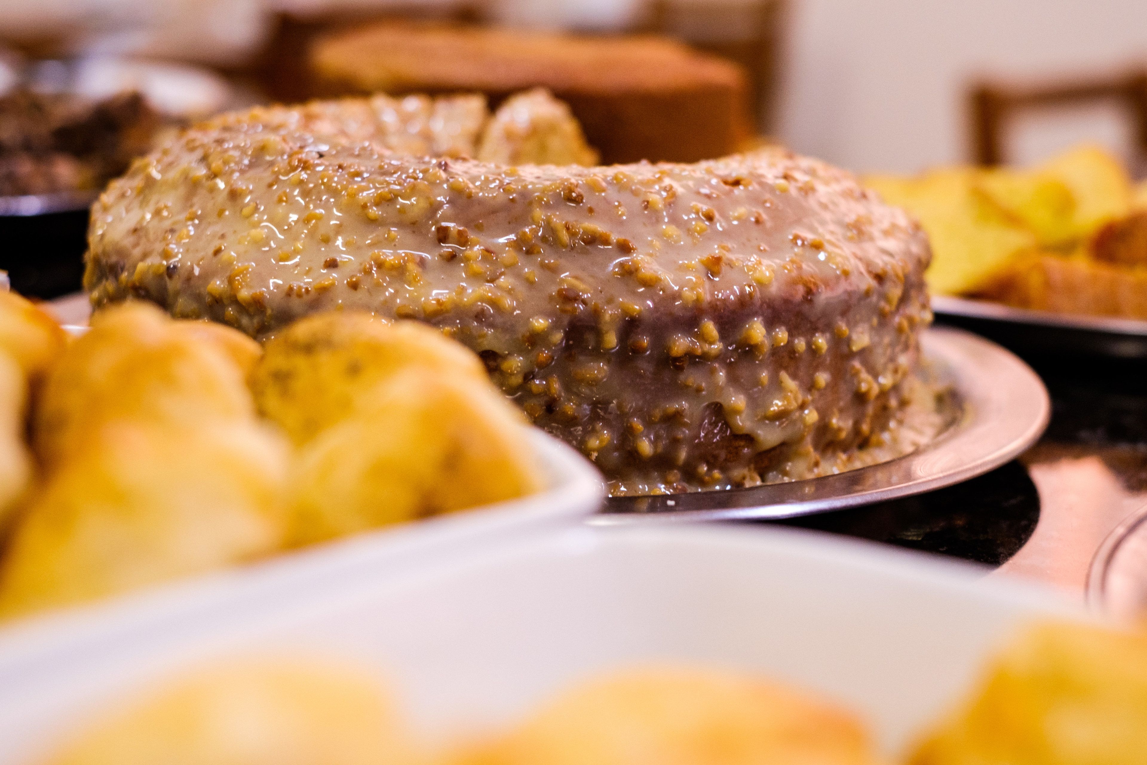 Un gâteau à la surface texturée et une assiette remplie d’autres pâtisseries.