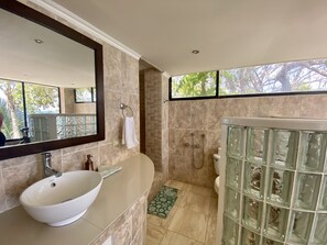A bathroom with a white sink, a glass-enclosed shower, and a large mirror.