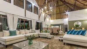 Un amplio salón con techo alto, ventanas grandes y zona de comedor.