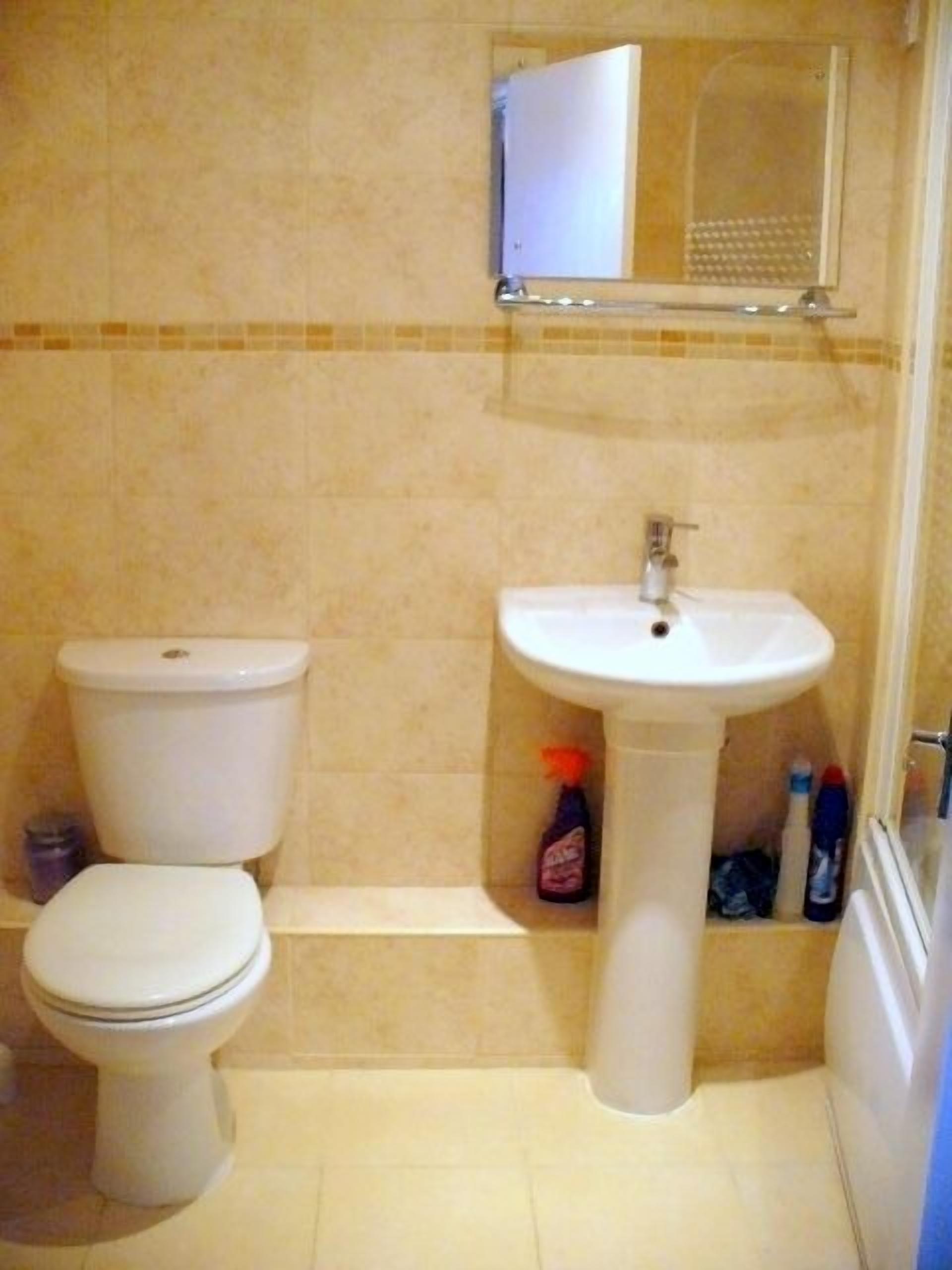 Un bagno con il water, un lavandino e uno specchio.
