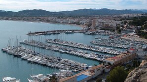 A marina with numerous boats docked, a coastal town in the background, and mountains in the distance. - 3 bed 2 bath family villa, close to beach, Smart TV, WIFI and air con (Javea)