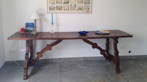 A wooden table with a framed picture of Elba on the wall behind it. - Sea-view cottage a stone's throw from the beach near Capoliveri (Capoliveri)