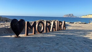 Een strand met een sculptuur in de vorm van een hart en de tekst 'MORARA' in grote letters.