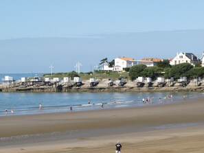 A beach with people swimming and walking, houses in the background, and lifeguard towers. - house / villa - Saujon (Corme-Écluse)