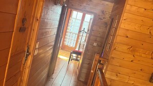 A wooden interior with a hallway leading to a door with a window. - Authentic sheepfold renovated  (Sazos)