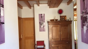 Une pièce avec un meuble en bois, une chaise et une porte.