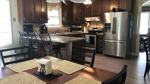 Une cuisine moderne avec des meubles en bois foncé, des appareils électroménagers en acier inoxydable et un îlot central.