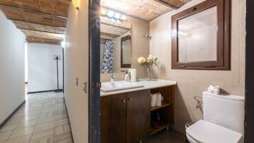 Een bad/douchecombinatie, een haardroger, handdoeken, zeep