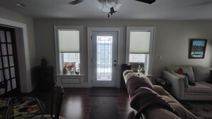 A living room with a sofa, a coffee table, and a door with a window.