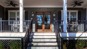 A covered porch with a wooden door, two columns, and a sign reading "Rockbrook Manor."