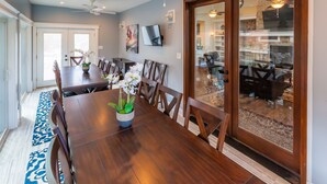 A dining area with a wooden table, chairs, and a vase of flowers.
