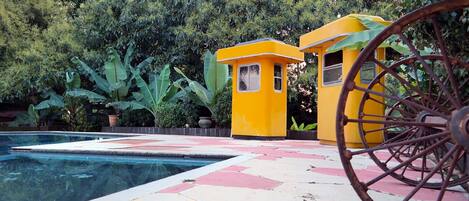 Una zona de piscina con una estructura amarilla y un neumático grande.