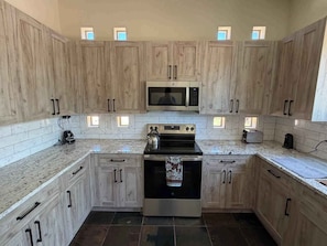 A kitchen with wooden cabinets, a microwave, a stove, and a dishwasher.