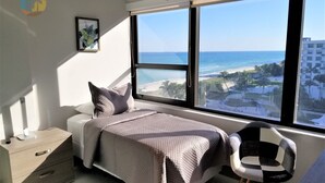 A modern bedroom with a large window overlooking a beach and ocean. - Large Modern 4 Bedroom Beautiful Ocean Views-1003 (Miami Beach)