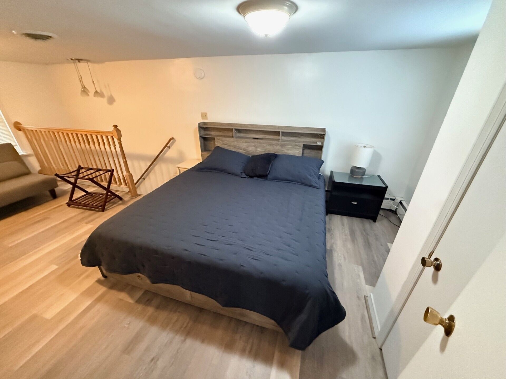 Une chambre à coucher avec un lit, une table de chevet, une chaise et une porte.