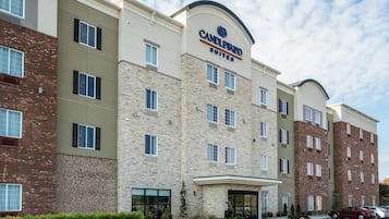 A multi-story hotel with a stone facade, multiple windows, and a clear sky.