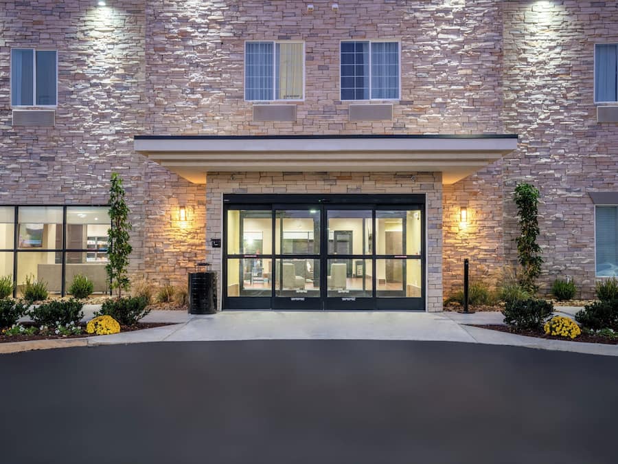 A building with a stone facade, large glass entrance, and outdoor seating area.