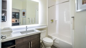 A bathroom with a sink, mirror, toilet, and bathtub. - Candlewood Suites Nashville - Franklin by IHG (Franklin)
