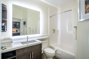 Ein Badezimmer mit Waschbecken, Spiegel, Toilette und Badewanne.