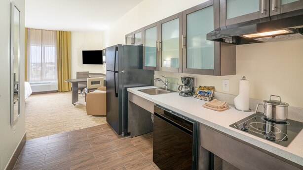A modern kitchen with a built-in dishwasher, a coffee maker, and a kettle on the counter. - Candlewood Suites Nashville - Franklin by IHG (Franklin)