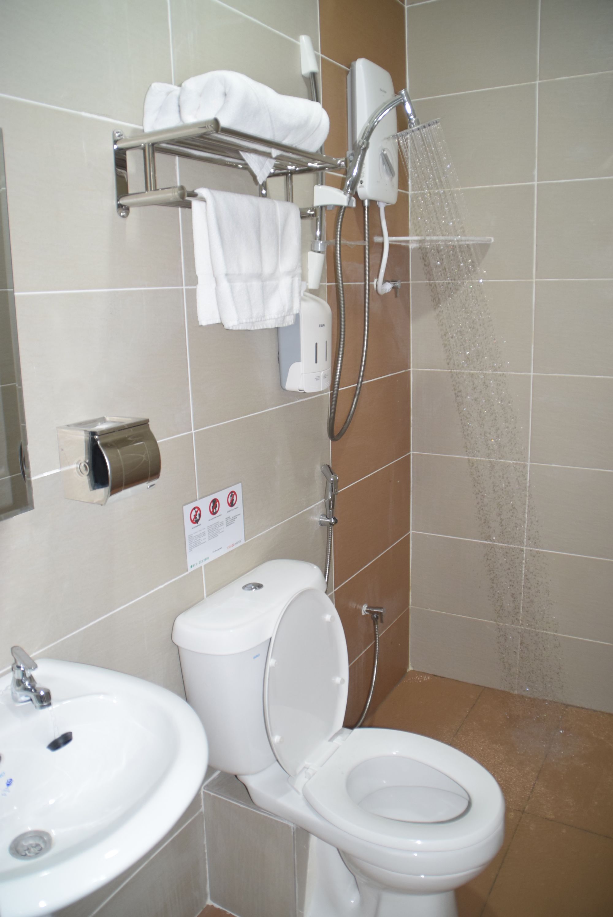 A bathroom with a toilet, sink, and shower.