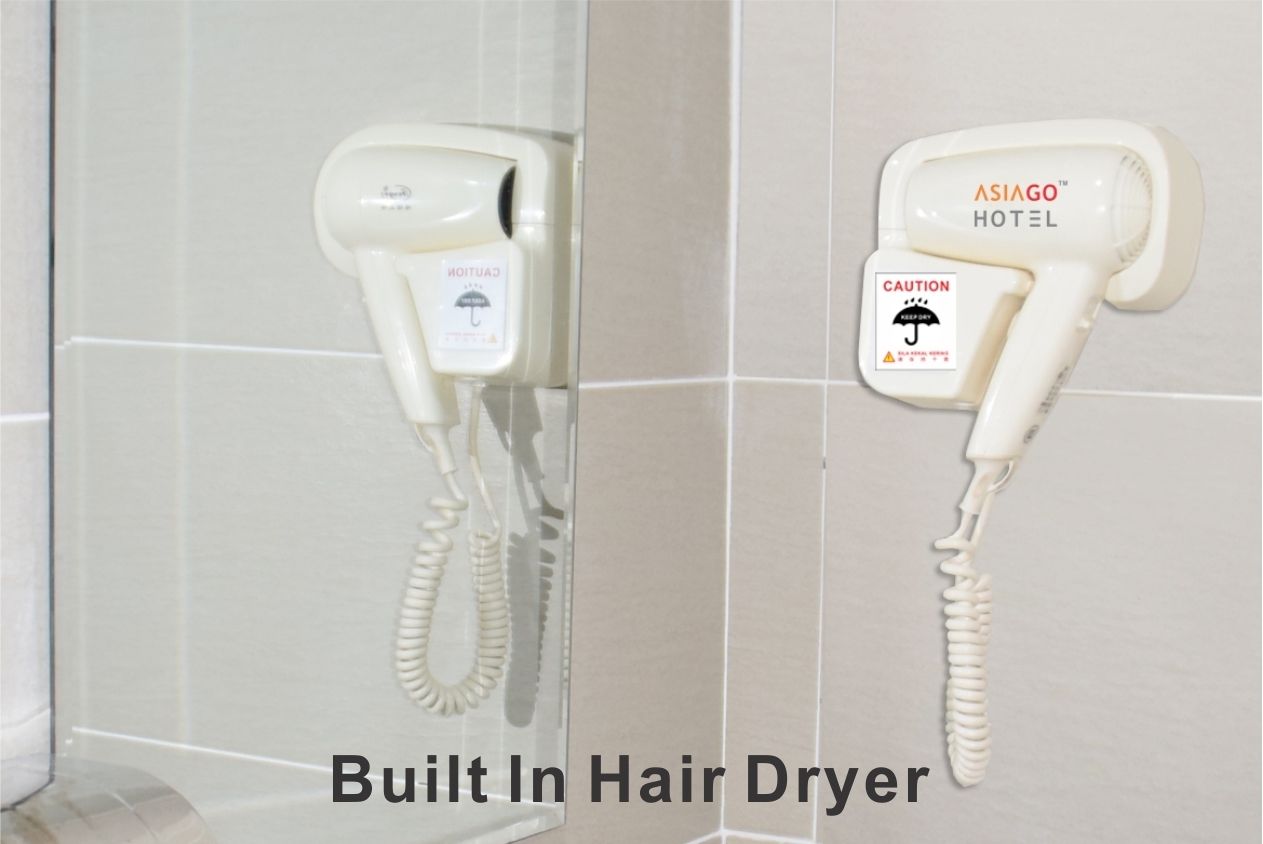 A built-in hair dryer in a bathroom with caution labels.
