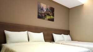 Habitación de hotel con dos camas, cabecero de madera y un cuadro en la pared.