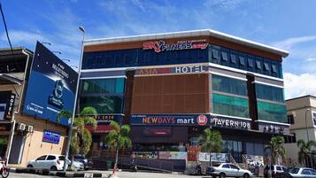 A multi-story building with signage for 'Pusat Gimnasium' and 'Asiago Hotel'.